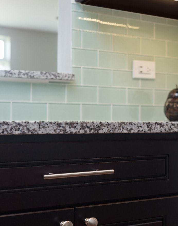 Inspiration for a mid-sized contemporary u-shaped eat-in kitchen remodel in Chicago with an undermount sink, beaded inset cabinets, dark wood cabinets, granite countertops, green backsplash, subway tile backsplash, stainless steel appliances and no island