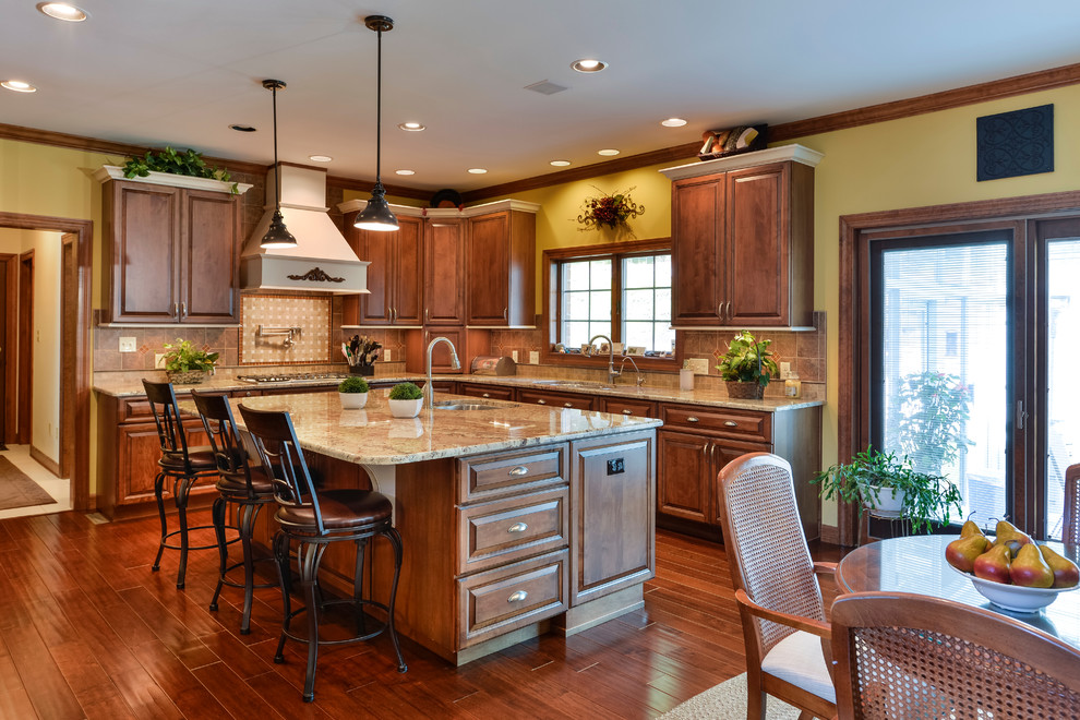 Inspiration for a large transitional u-shaped medium tone wood floor eat-in kitchen remodel with beaded inset cabinets, medium tone wood cabinets, granite countertops, beige backsplash, mosaic tile backsplash, stainless steel appliances and an island