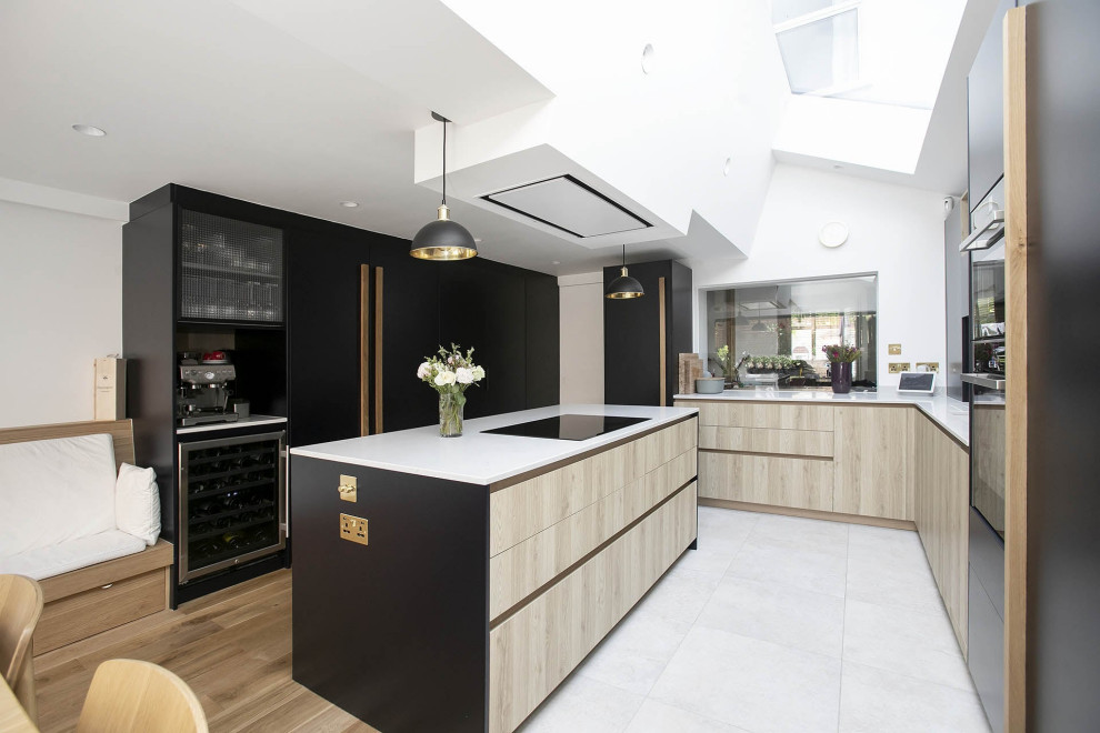 Photo of a small contemporary l-shaped open plan kitchen in London with an undermount sink, beaded inset cabinets, black cabinets, quartzite benchtops, white splashback, ceramic splashback, black appliances, ceramic floors, with island, multi-coloured floor, white benchtop and vaulted.