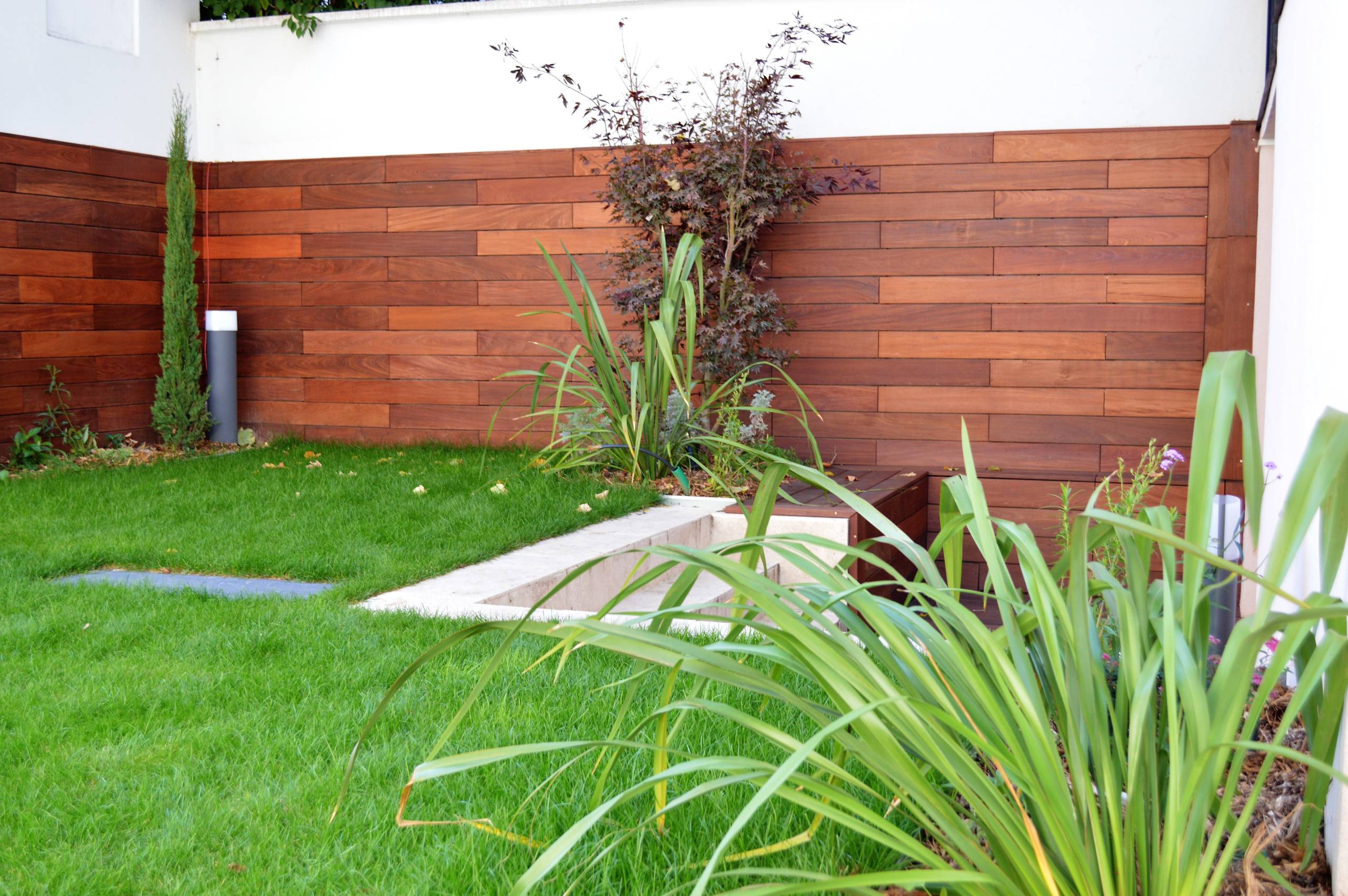 La terrasse basse délimitée par un rappel de matériaux posé à l'horizontal et à