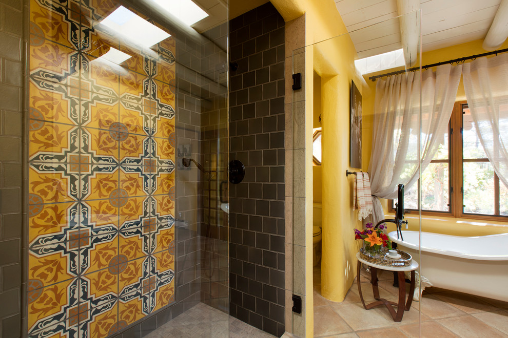 Photo of a mid-sized eclectic master bathroom in Albuquerque with a claw-foot tub, an open shower, multi-coloured tile, cement tile, yellow walls, porcelain floors and tile benchtops.