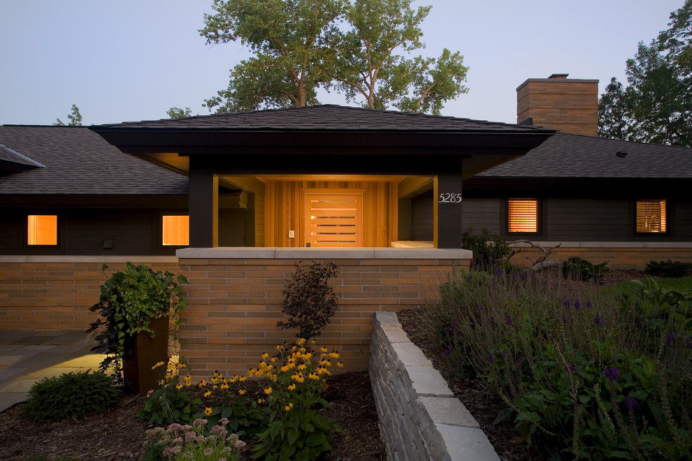 Large contemporary one-storey black exterior in Minneapolis with a hip roof, mixed siding and a shingle roof.