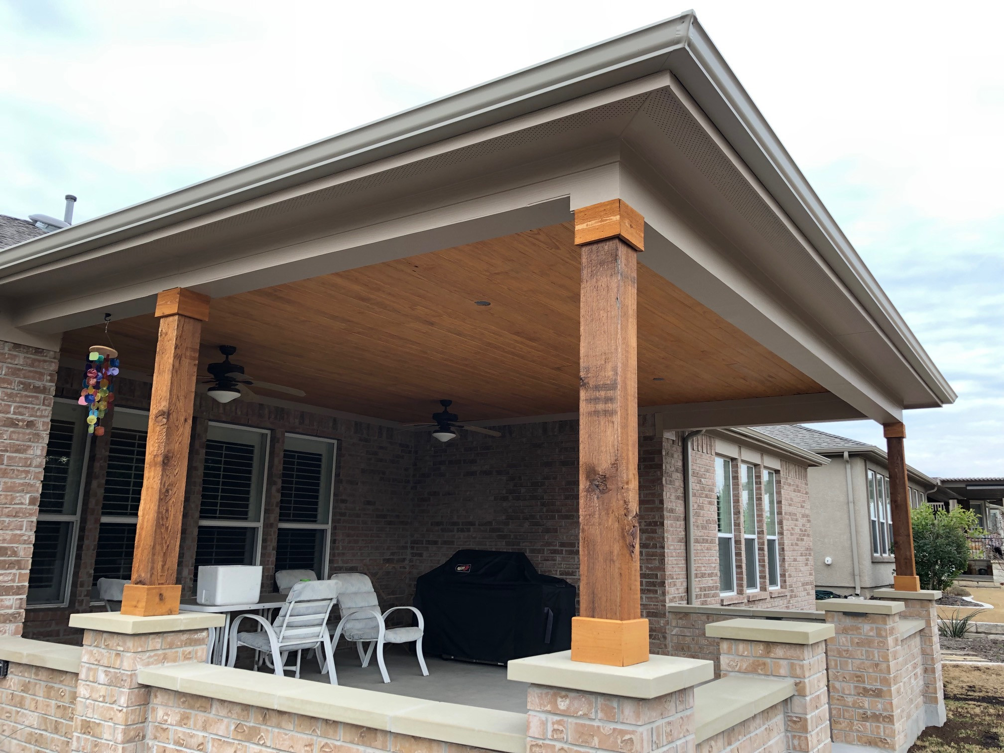 Shingled roof extension with stained cedar tongue & groove ceiling, concrete pat