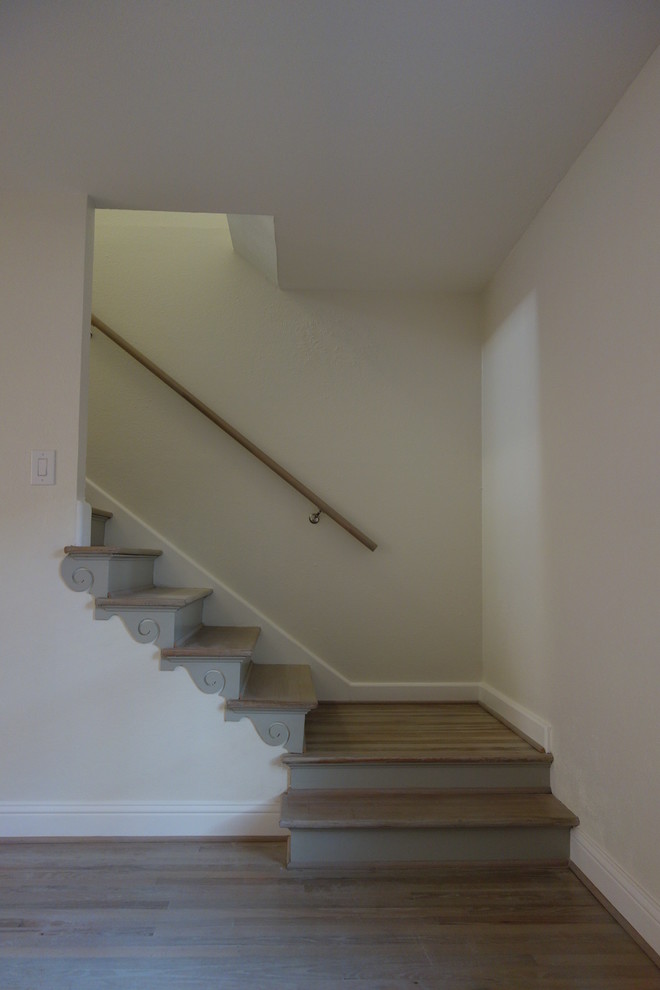 This is an example of a small transitional wood staircase in Dallas with wood risers.