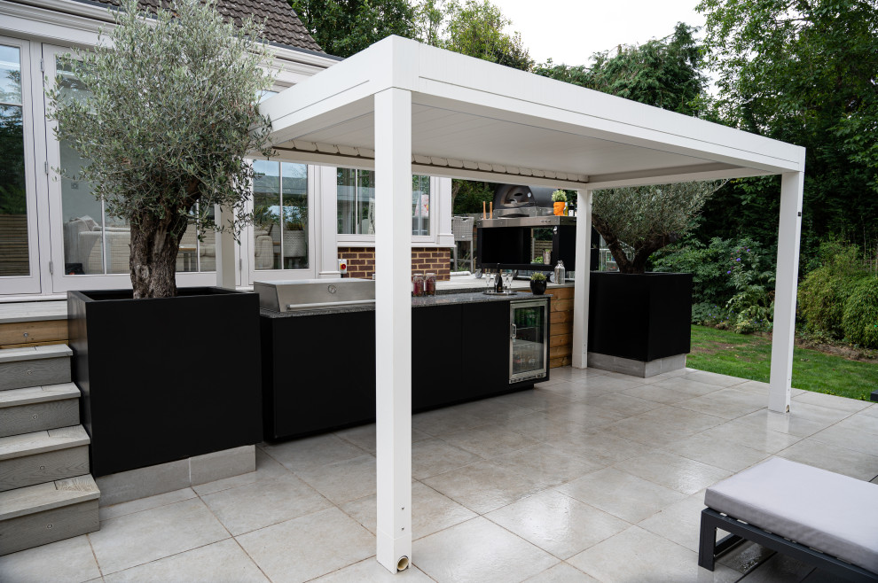 This is an example of a large modern back driveway full sun pergola for summer in Essex.