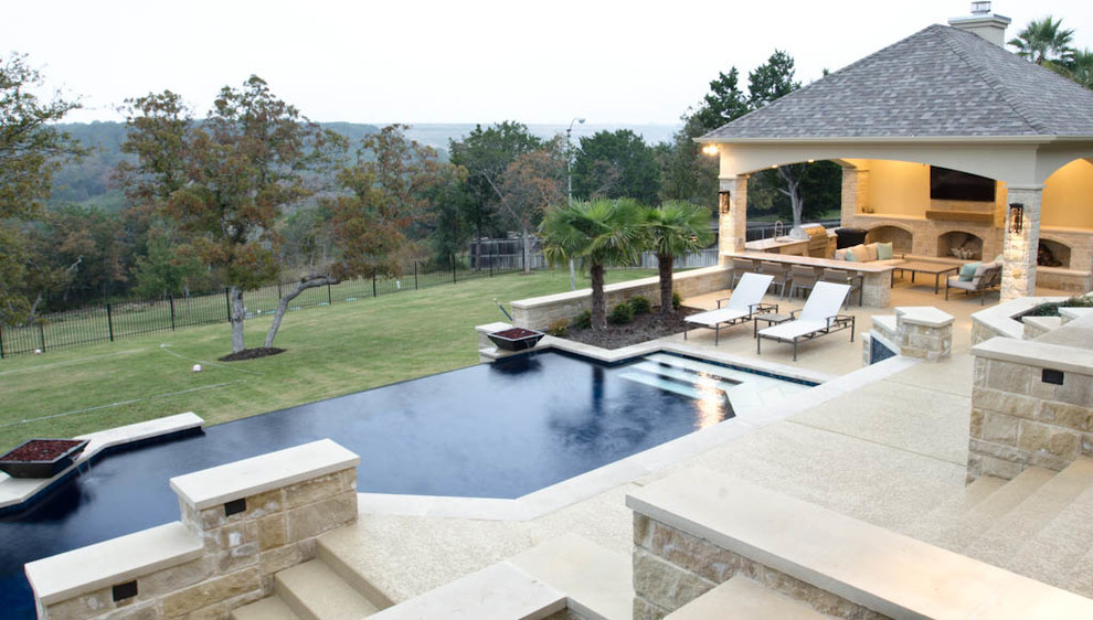 Design ideas for an expansive contemporary backyard rectangular infinity pool in Austin with concrete slab.