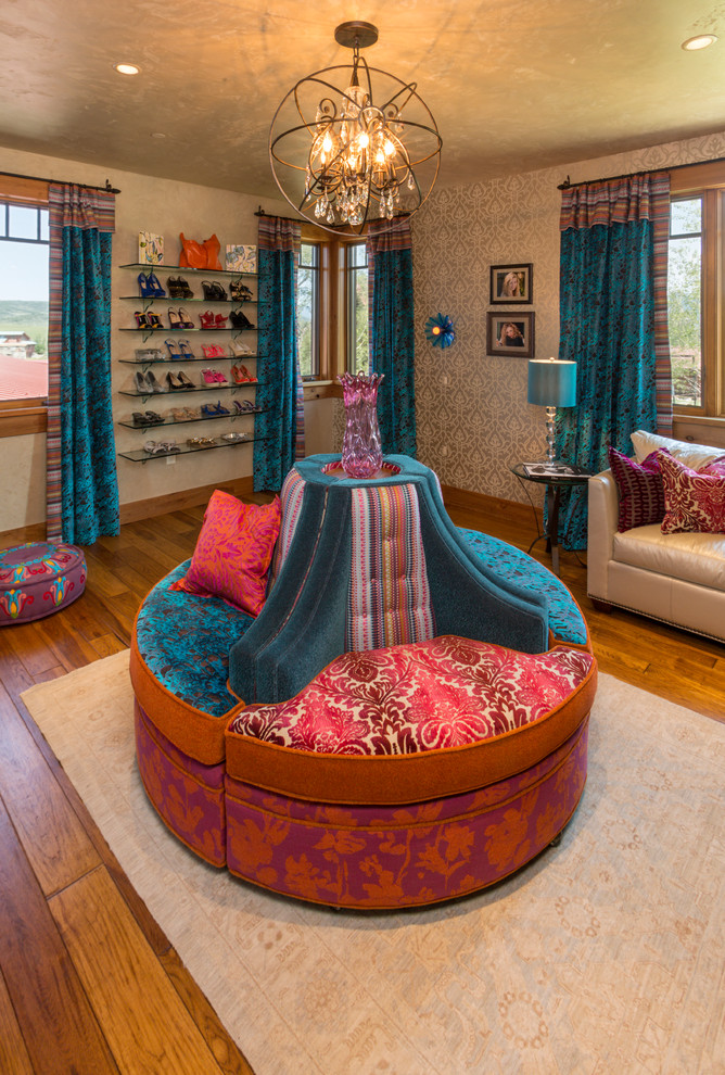 Inspiration for a large eclectic women's dressing room in Denver with medium hardwood floors, open cabinets and brown floor.