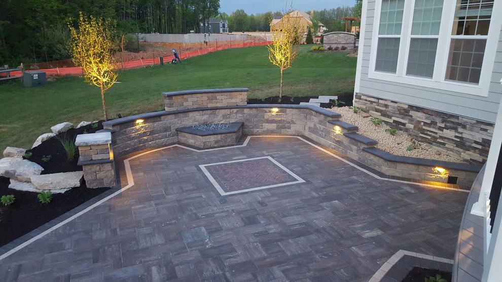 Design ideas for a large contemporary backyard patio in Columbus with a fire feature, brick pavers and no cover.
