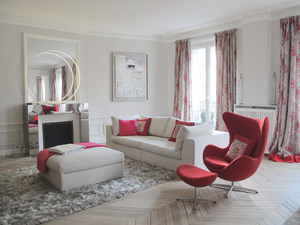 This is an example of a large contemporary formal enclosed living room in Paris with grey walls, light hardwood floors, a standard fireplace and no tv.