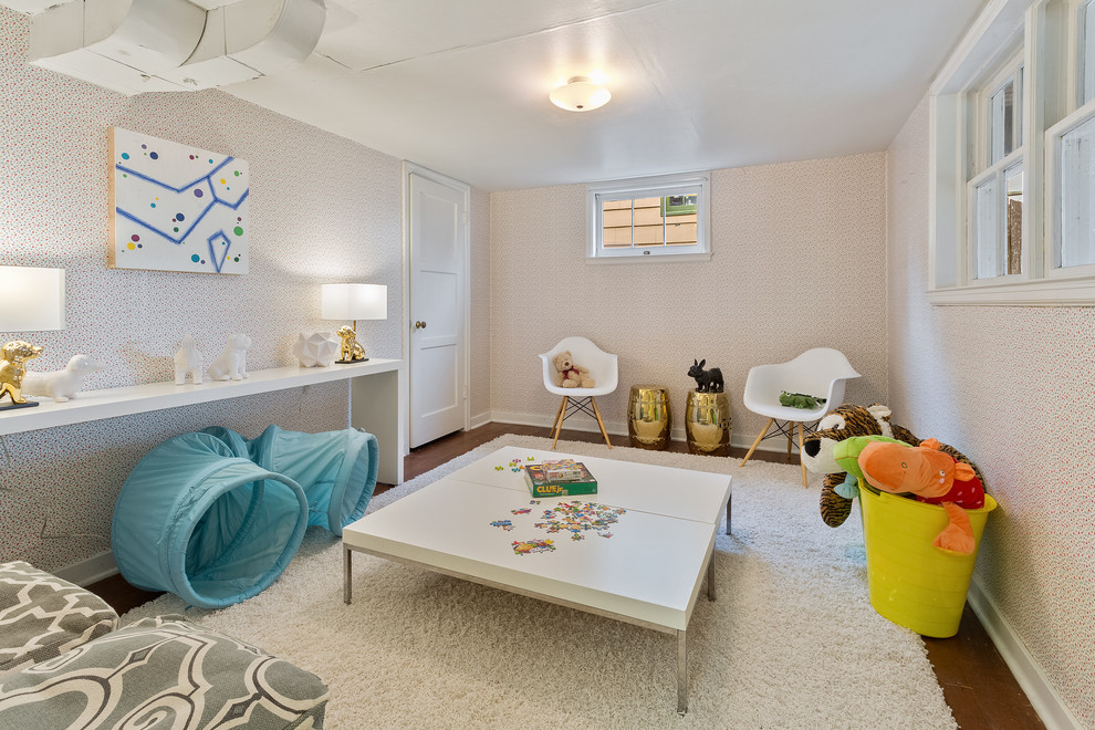 This is an example of a transitional gender-neutral kids' playroom for kids 4-10 years old in Seattle with multi-coloured walls and dark hardwood floors.