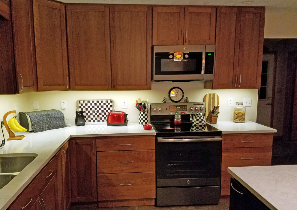 This is an example of a mid-sized transitional l-shaped eat-in kitchen in Other with an undermount sink, shaker cabinets, medium wood cabinets, quartz benchtops, stainless steel appliances, ceramic floors, with island, yellow floor and white benchtop.
