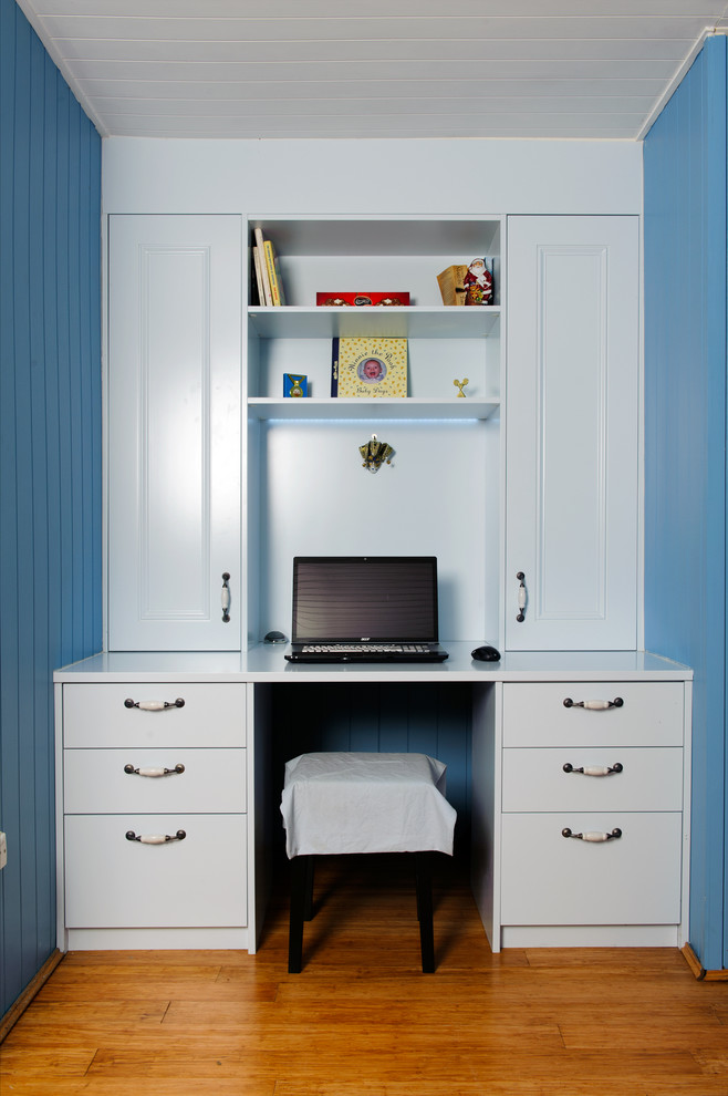 Photo of a mid-sized transitional teen room for boys in Sydney with blue walls and dark hardwood floors.