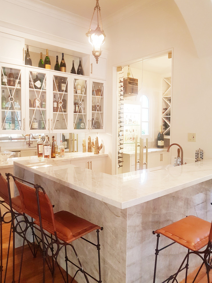 Design ideas for a transitional home bar with medium hardwood floors.