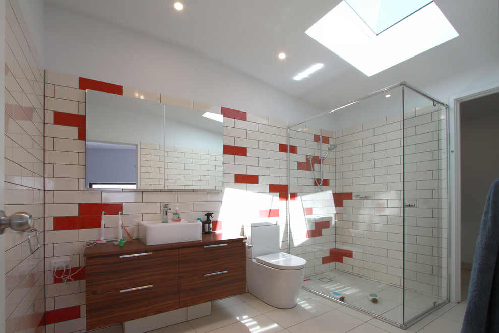 Design ideas for a transitional 3/4 bathroom in Melbourne with flat-panel cabinets, medium wood cabinets, a freestanding tub, an alcove shower, white tile, subway tile, white walls, a vessel sink, wood benchtops and brown floor.