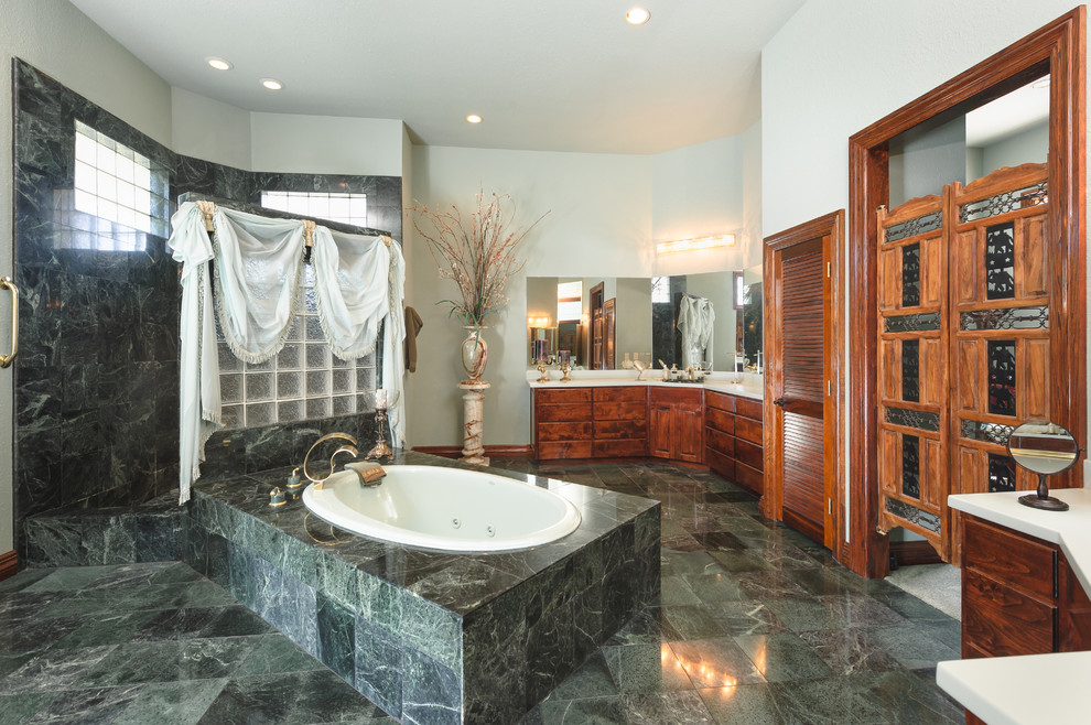Photo of an expansive traditional master bathroom in Dallas with raised-panel cabinets, dark wood cabinets, a drop-in tub, a corner shower, green tile, stone tile, green walls, marble floors and a drop-in sink.