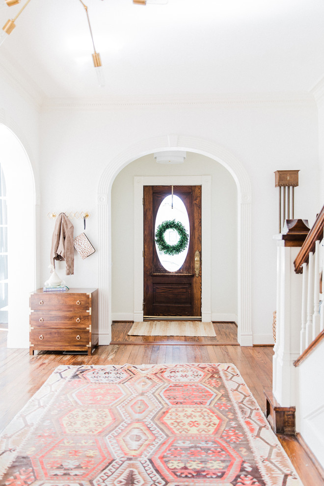 Design ideas for a transitional entryway in Houston with white walls, medium hardwood floors, a single front door, a dark wood front door and brown floor.