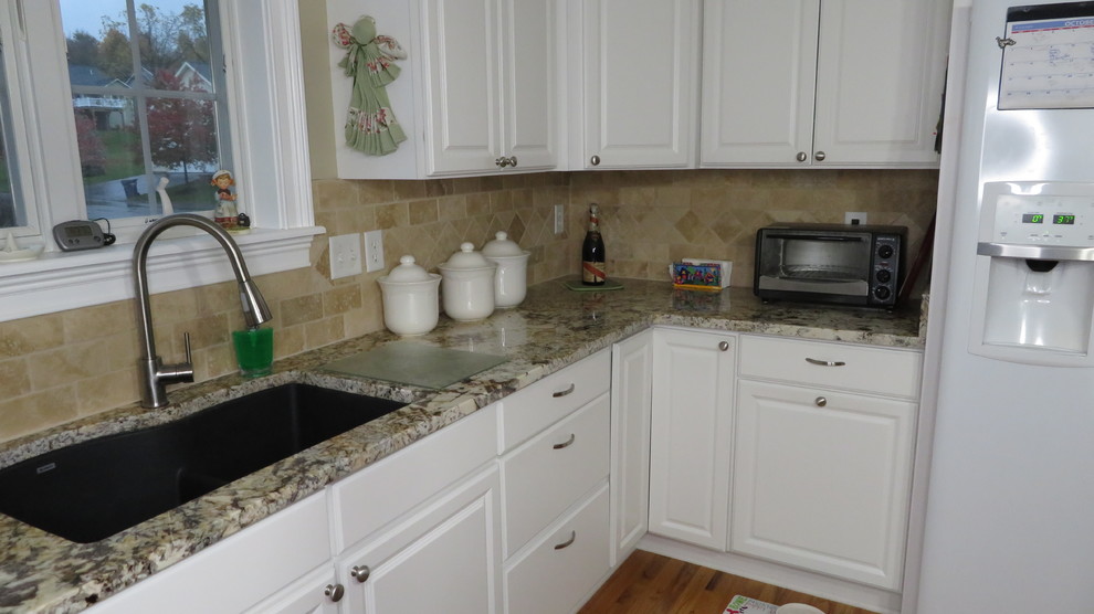 Kitchen - mid-sized traditional u-shaped kitchen idea with an undermount sink, raised-panel cabinets, white cabinets, granite countertops, multicolored backsplash, travertine backsplash, white appliances and multicolored countertops