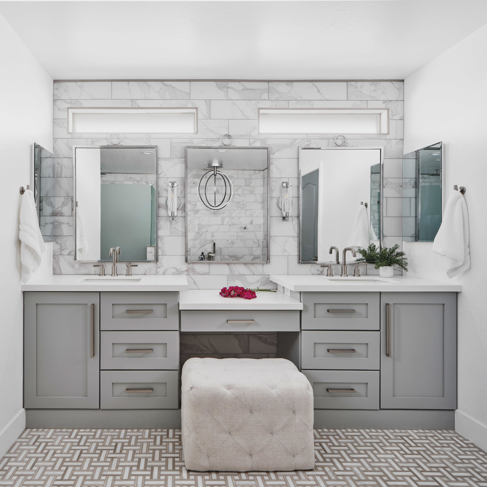 This is an example of a mid-sized transitional master bathroom in Phoenix with shaker cabinets, grey cabinets, a freestanding tub, a corner shower, white tile, porcelain tile, white walls, ceramic floors, an undermount sink, engineered quartz benchtops, beige floor, a hinged shower door and white benchtops.