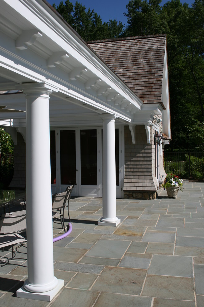 This is an example of a large victorian backyard rectangular lap pool in New York with a pool house and stamped concrete.