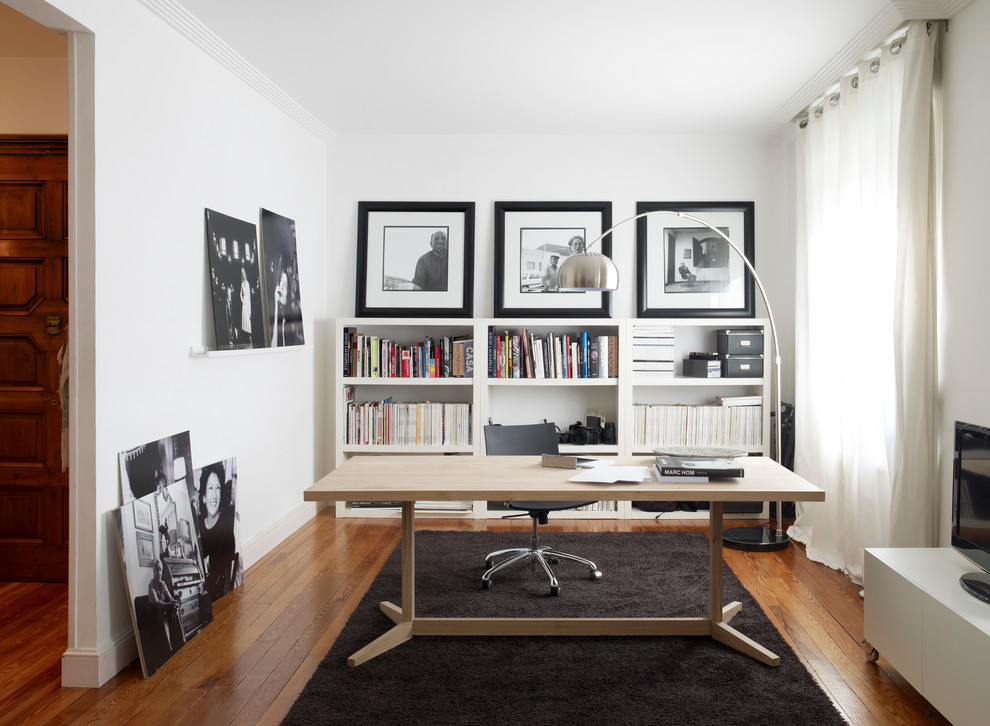 Inspiration for a mid-sized contemporary study room in Bordeaux with white walls, medium hardwood floors, a freestanding desk and brown floor.