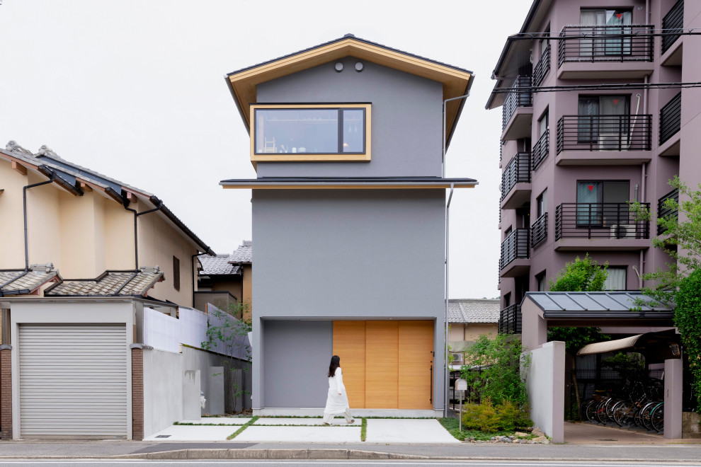 This is an example of a mid-sized asian three-storey grey house exterior in Kyoto with mixed siding, a gable roof, a metal roof, a black roof and shingle siding.