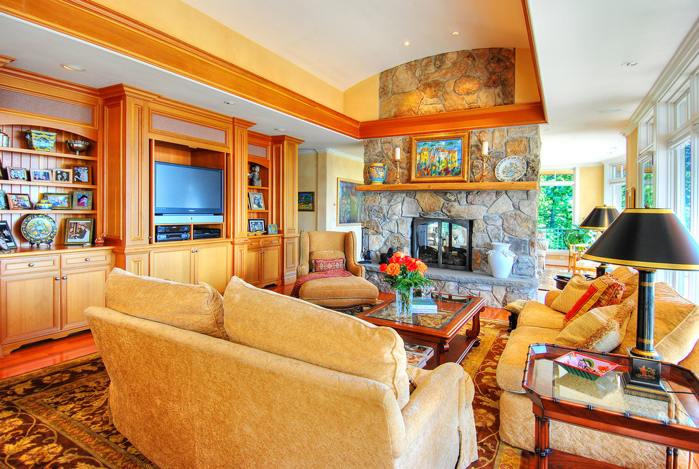 This is an example of a large traditional formal open concept living room in Seattle with yellow walls, dark hardwood floors, a two-sided fireplace, a stone fireplace surround and a built-in media wall.