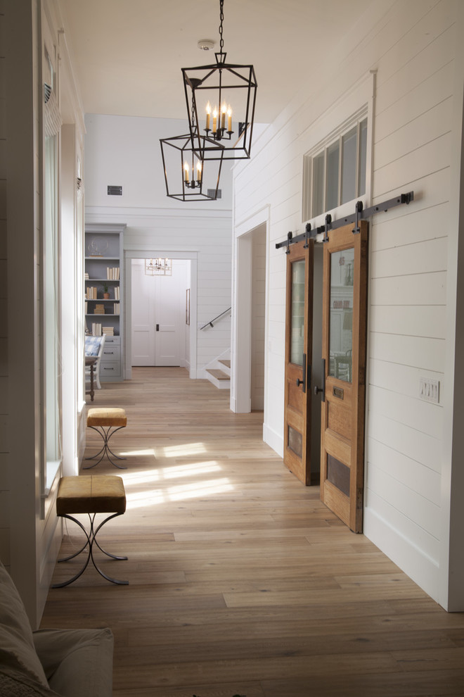 Design ideas for a large country hallway in Tampa with light hardwood floors and brown floor.