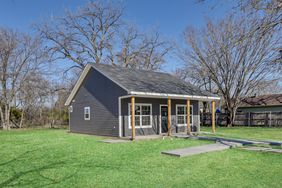 Photo of a small country one-storey grey house exterior in Dallas with concrete fiberboard siding, a gable roof and a tile roof.
