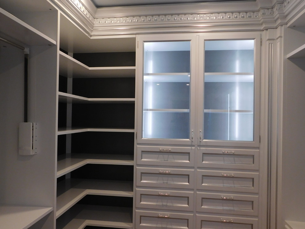 Design ideas for a large mediterranean women's walk-in wardrobe in DC Metro with glass-front cabinets, white cabinets and medium hardwood floors.
