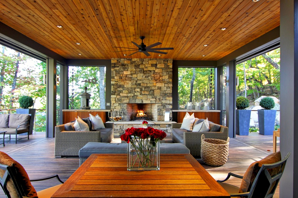 Design ideas for a large contemporary backyard deck in Raleigh with a fire feature and a roof extension.
