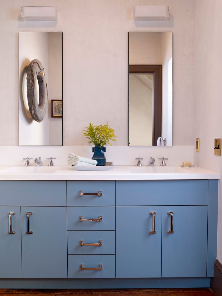 Inspiration for an eclectic bathroom in New York with flat-panel cabinets and blue cabinets.