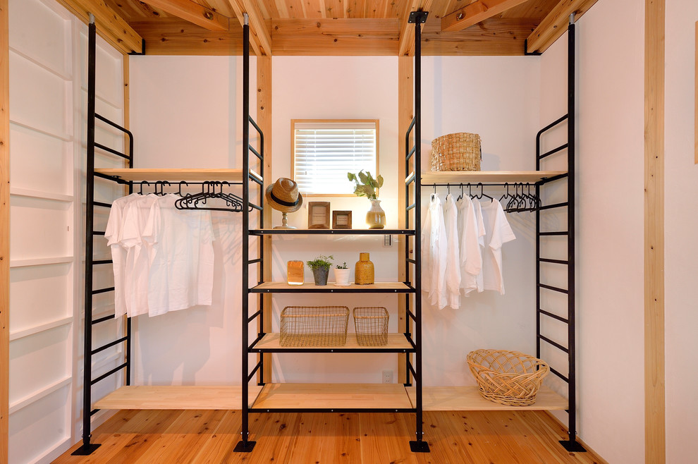 Стильный дизайн: шкаф в нише в стиле лофт с паркетным полом среднего тона и коричневым полом - последний тренд