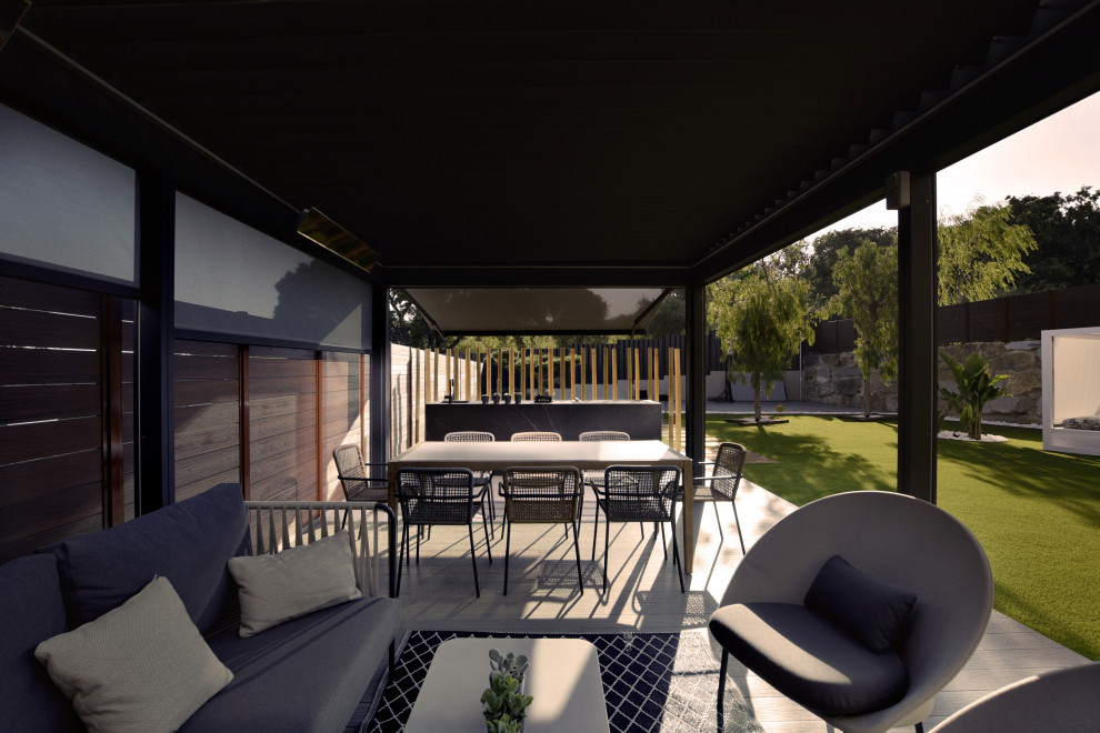 Photo of a mid-sized mediterranean courtyard deck in Barcelona with an outdoor kitchen and a pergola.