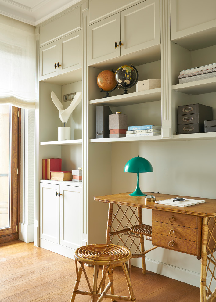 Idee per uno studio eclettico con libreria, pareti beige, pavimento in legno massello medio e scrivania autoportante