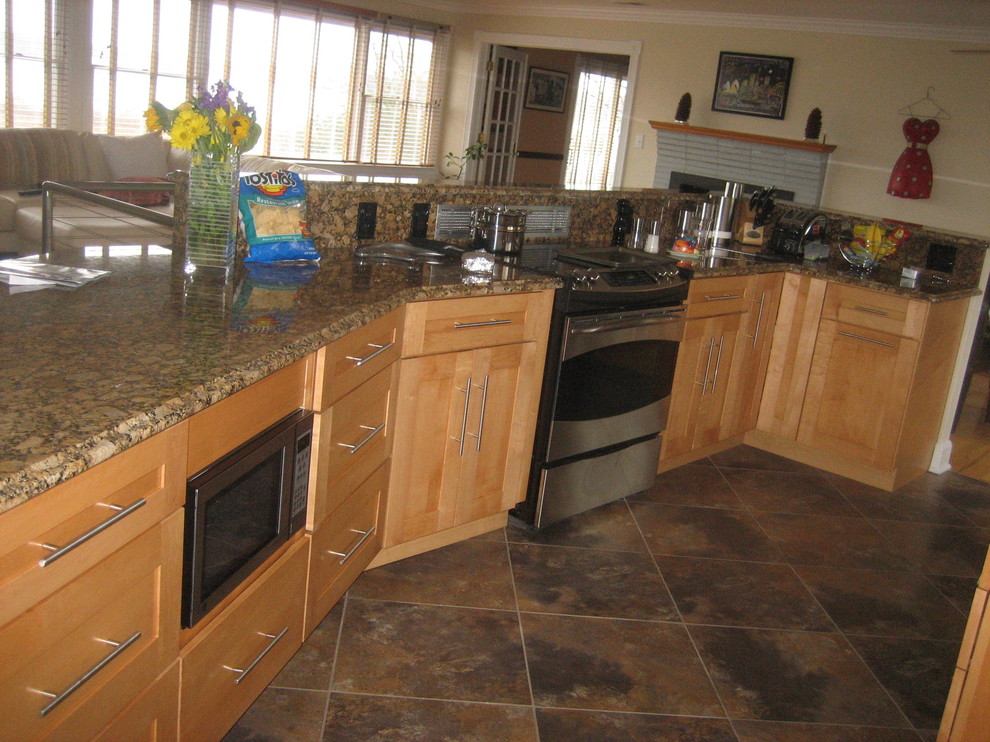 Single-wall open concept kitchen photo in Baltimore with an undermount sink, flat-panel cabinets, light wood cabinets, granite countertops, beige backsplash, stone slab backsplash and stainless steel appliances