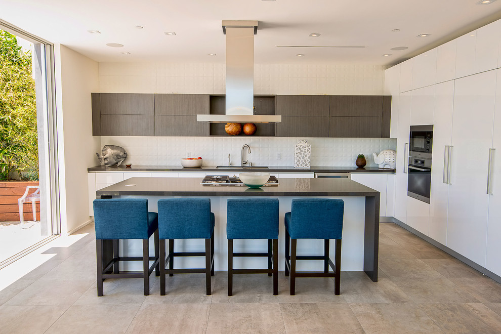 Contemporary l-shaped kitchen in Los Angeles with flat-panel cabinets, white cabinets, white splashback, stainless steel appliances and with island.