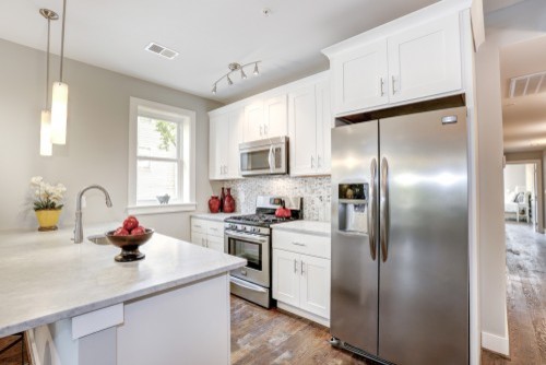 Eat-in kitchen - small transitional medium tone wood floor eat-in kitchen idea in DC Metro with an undermount sink, shaker cabinets, white cabinets, marble countertops, gray backsplash, stainless steel appliances and an island