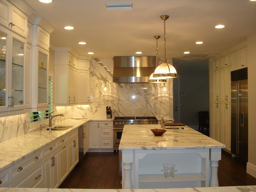 Inspiration for a large transitional u-shaped dark wood floor eat-in kitchen remodel in Miami with raised-panel cabinets, white cabinets, an island, an undermount sink, marble countertops, white backsplash, stone slab backsplash and stainless steel appliances