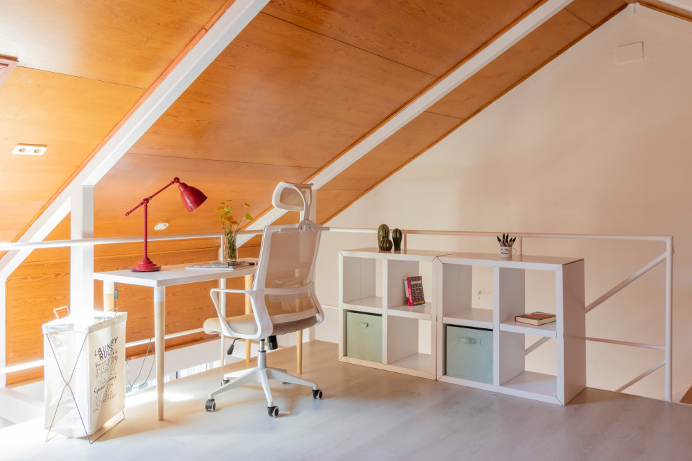 Ejemplo de despacho abovedado nórdico de tamaño medio con paredes beige, suelo laminado, escritorio independiente y suelo gris