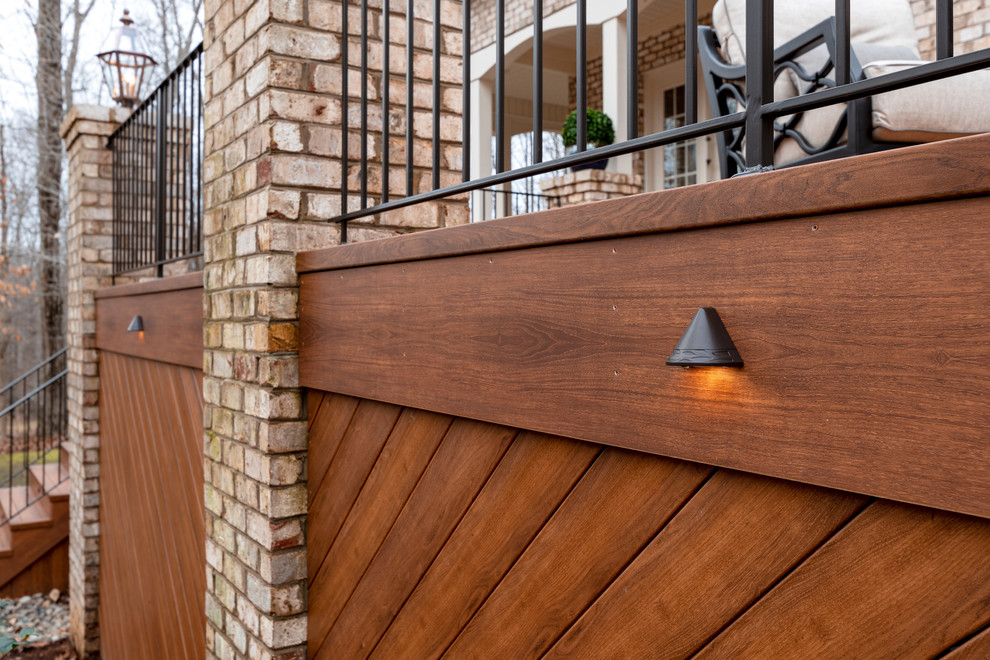 Example of a large transitional backyard deck design with a fire pit and no cover