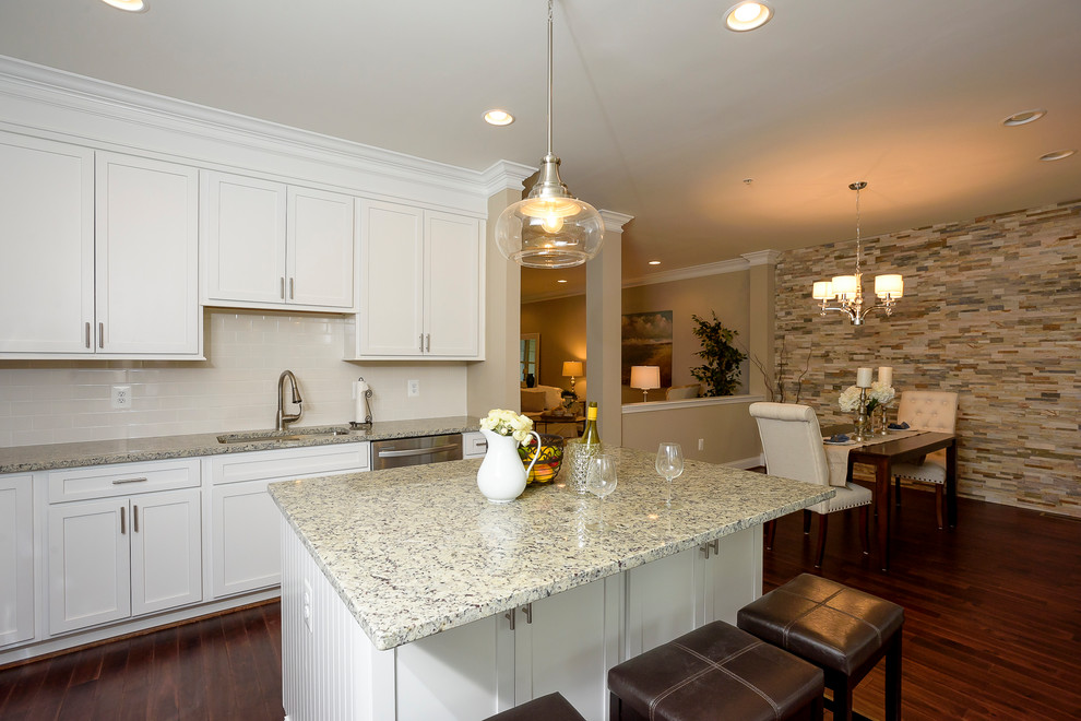 Mid-sized transitional l-shaped dark wood floor and red floor eat-in kitchen photo in Baltimore with an undermount sink, shaker cabinets, white cabinets, granite countertops, beige backsplash, ceramic backsplash, stainless steel appliances and an island