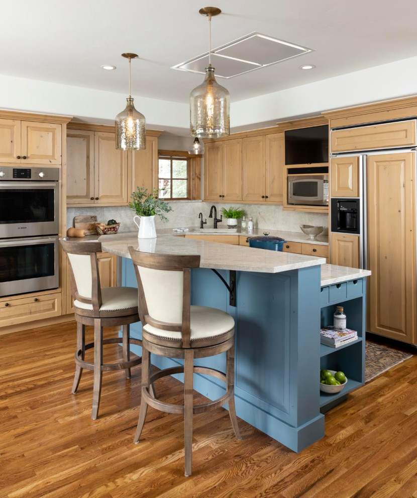 This is an example of a mid-sized transitional l-shaped kitchen in Denver with quartzite benchtops, white splashback, marble splashback, medium hardwood floors, multiple islands, brown floor and white benchtop.