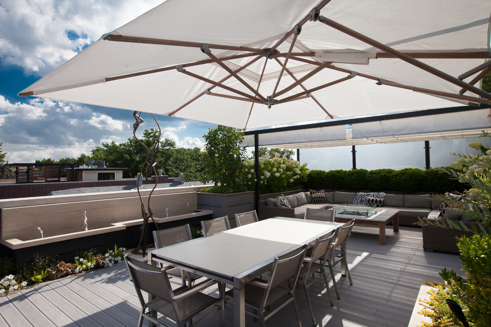 This is an example of a mid-sized contemporary rooftop deck in Chicago with a water feature and a pergola.