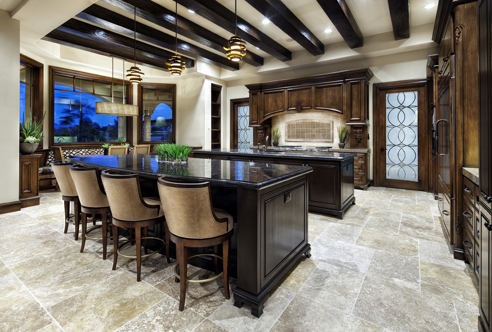 Inspiration for a mediterranean kitchen in Dallas with raised-panel cabinets, dark wood cabinets and black benchtop.