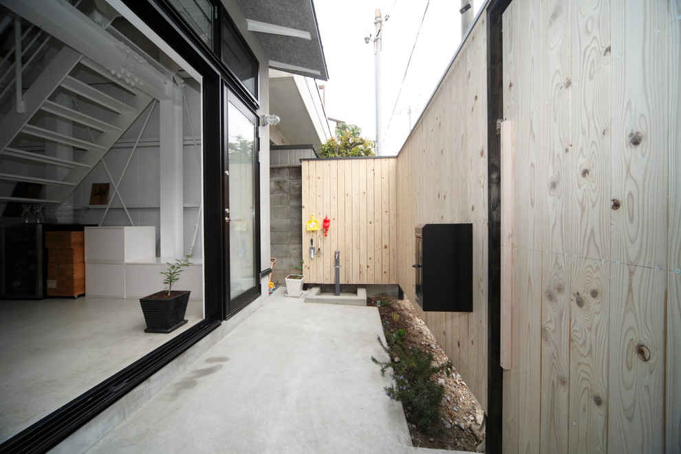 Exemple d'un porche d'entrée de maison latéral asiatique de taille moyenne avec jupe de finition et des pavés en béton.