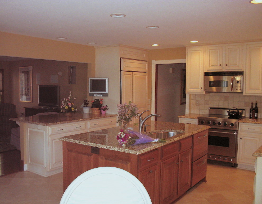 Inspiration for a transitional ceramic tile eat-in kitchen remodel in Philadelphia with an undermount sink, raised-panel cabinets, granite countertops, multicolored backsplash, ceramic backsplash, stainless steel appliances and an island