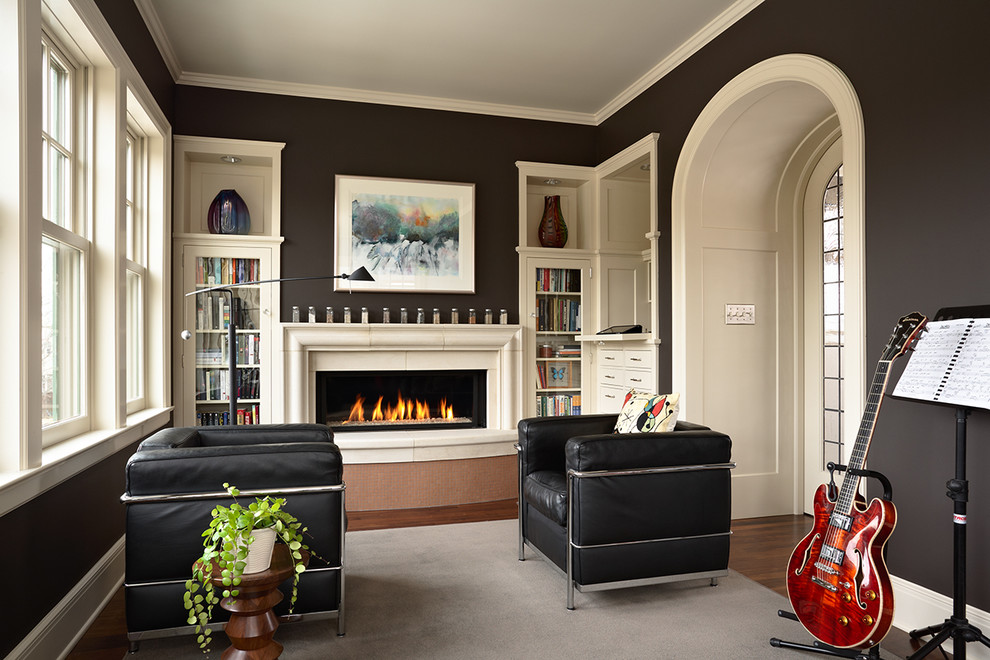Photo of a mid-sized transitional enclosed family room in Minneapolis with a music area, dark hardwood floors, a standard fireplace, a stone fireplace surround, no tv, black walls and brown floor.