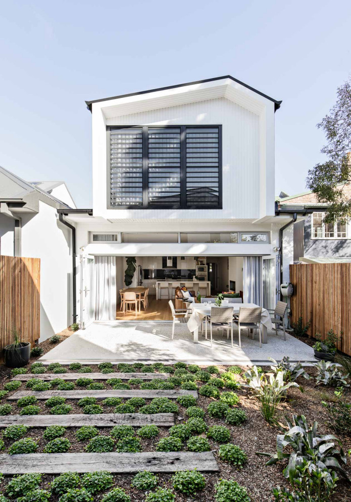 Inspiration for a mid-sized contemporary two-storey white house exterior in Sydney with wood siding, a gable roof and a metal roof.