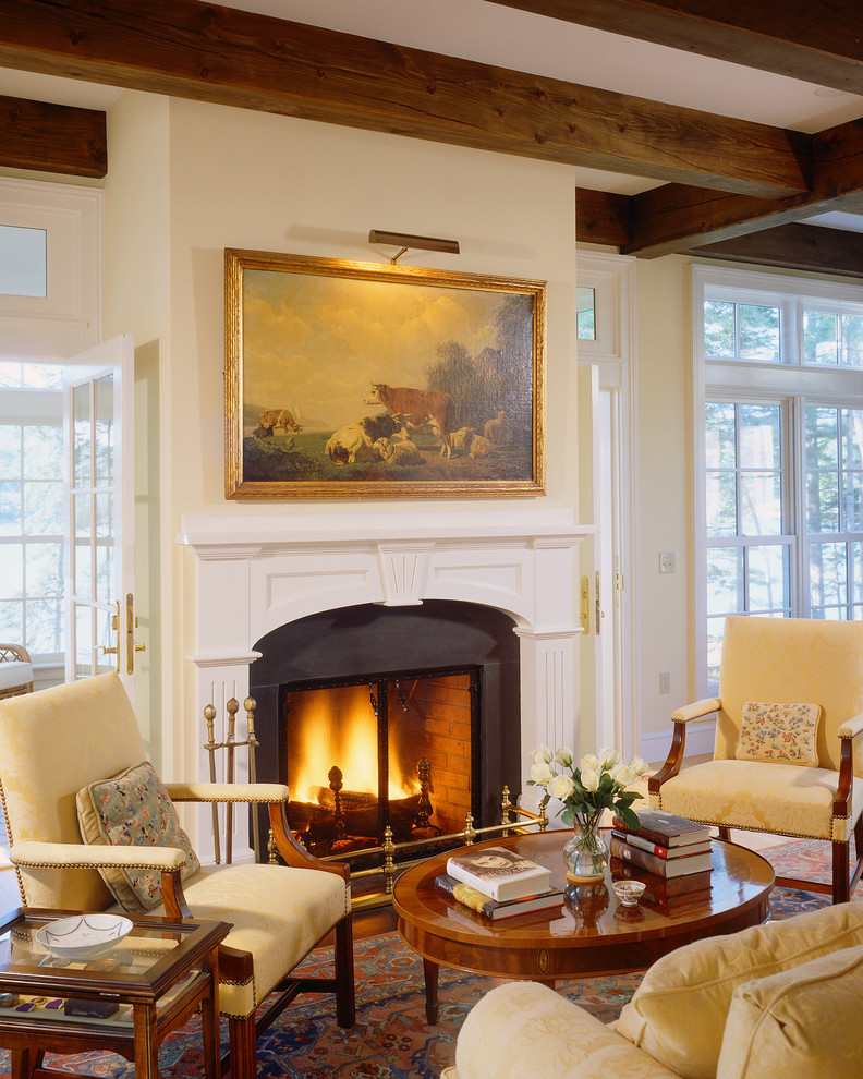 Inspiration for a traditional living room in Portland Maine with white walls, dark hardwood floors and a standard fireplace.