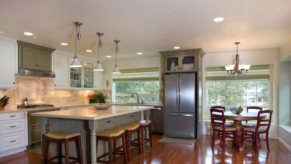 Open concept kitchen - mid-sized transitional l-shaped medium tone wood floor open concept kitchen idea with a double-bowl sink, raised-panel cabinets, white cabinets, white backsplash, stainless steel appliances and an island